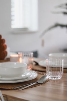 the table is set with white dishes and silverware