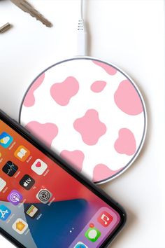 an iphone with a pink and white polka dot pattern next to a car charger