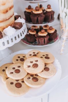 cookies and cupcakes are arranged on a table