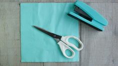 a pair of scissors sitting on top of a blue napkin