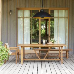 a wooden table sitting on top of a wooden floor next to a tall lamp shade