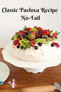 a cake with berries and kiwis on top is sitting on a white plate