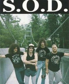 a group of young men standing next to each other in front of a sign that says sod speak english or die