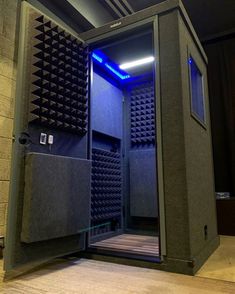 a room that has some kind of sound system in the corner with blue lights on it