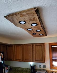 a kitchen with wooden cabinets and lights on the ceiling