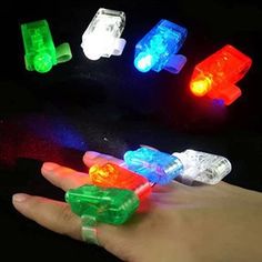 four different colored lights in the palm of someone's hand on a black background