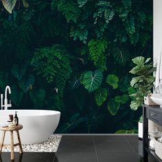 a bath tub sitting next to a wall covered in green plants and leaves on it