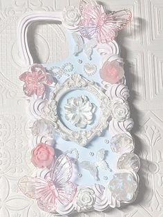 a cell phone case with flowers and butterflies on the front, sitting on a white background