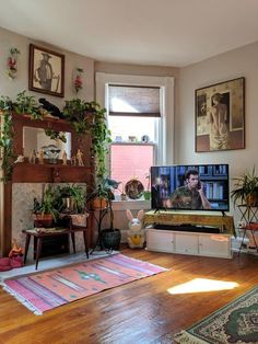 a living room filled with furniture and a flat screen tv sitting on top of a hard wood floor