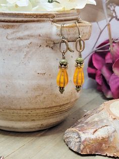 Make a statement with these rustic earrings. the antiqued brass dangle drops and Czech teardrop glass beads in mustard yellow, will make your favorite outfit complete. Premium Czech teardrop glass beads Premium Czech rondelle beads Vintaj Antiqued brass Brass lever back ear wires Drop 2" Created in studio - Wilmington, NC Earthy Earrings, Woodland Earrings, Rustic Earrings, Earrings Nature, Earrings Handmade Dangle, Teardrop Dangle Earrings, Rustic Jewelry, Wilmington Nc, Czech Beads