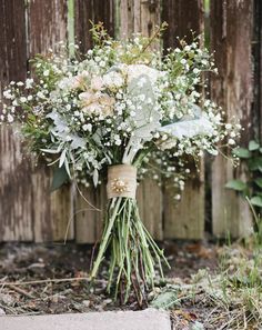 a bouquet of flowers sitting in front of a wooden fence