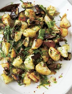 a white plate topped with potatoes and greens