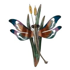 a metal sculpture with wings and flowers on it's back legs, sitting in front of a white background