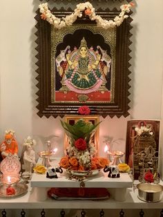 there is a shrine with flowers and candles on the table