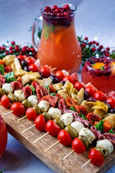 a wooden board topped with skewers filled with veggies and meats