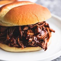 a pulled pork sandwich on a white plate