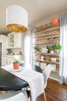 a dining room table with chairs and a potted plant on top of the table