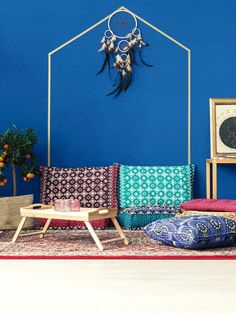 a living room with blue walls and colorful pillows