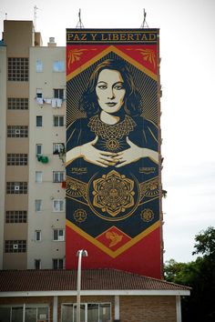 a large mural on the side of a building with a woman's face painted on it