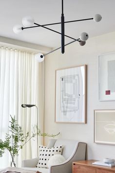 a living room filled with furniture and pictures on the wall next to a large window