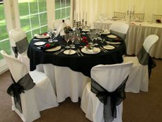 a dining room set up with black and white linens