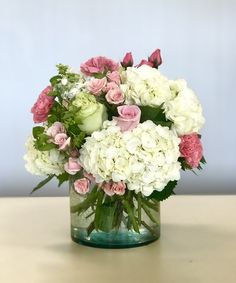 a vase filled with white and pink flowers