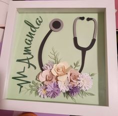 a shadow box with flowers and a stethoscope in it