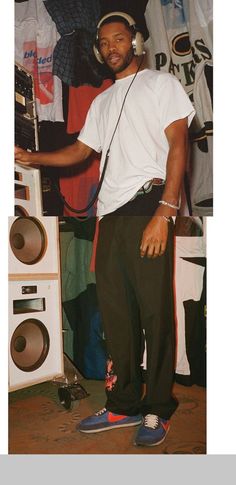 a man in headphones standing next to a boombox and speakers on the floor