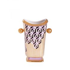 a glass vase with gold handles and geometric designs on the front, sitting on a white surface