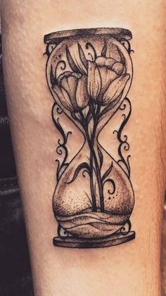 a black and white photo of an hourglass tattoo