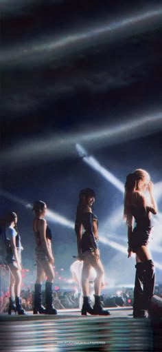 the group of women are performing on stage with their lights shining down in the background