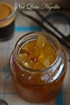 a glass jar filled with liquid sitting on top of a table next to spoons