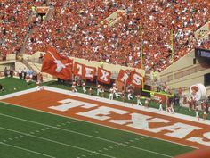 an orange and white football field with fans in the stands