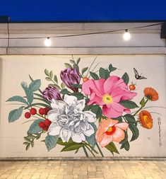 a mural on the side of a building with flowers painted on it's wall