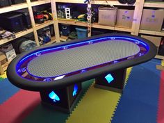 a black table with blue lights on it in a room filled with boxes and other items