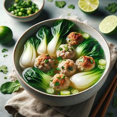 a bowl filled with meatballs and vegetables next to chopsticks on a table