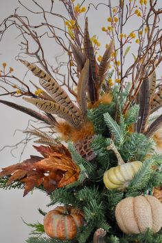 a vase filled with lots of different types of flowers and leaves on top of a table