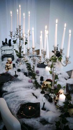 a table topped with lots of white candles