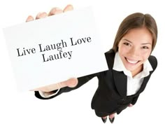 a woman holding up a sign that says live laugh love lauty