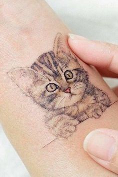 a small cat tattoo on the wrist