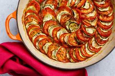 a pan filled with sliced tomatoes on top of a table