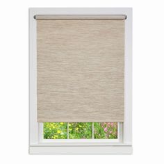 a window with a beige roller shade in front of the window and flowers behind it