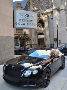 a black car parked in front of a building with a sign that says bentley gold coast