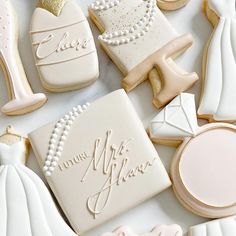 wedding cookies are arranged on a table with bride's dress and groom's shoes