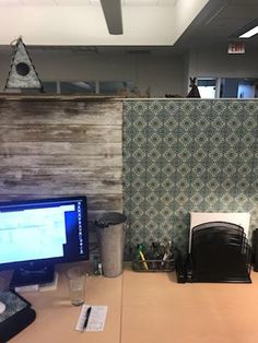 an office cubicle with two computer monitors on the desk