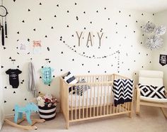 a baby's room with black and white wall decals on the walls, and a crib