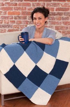 a woman sitting on a couch holding a coffee cup