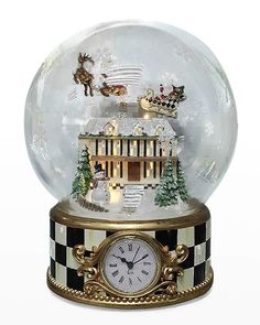 a snow globe with a clock and santa's sleigh scene inside it