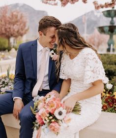 a bride and groom are sitting on a bench