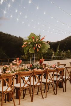 a table set up with flowers and greenery for an outdoor wedding reception in the mountains